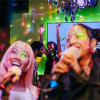 Two singers smile at the red-leather-clad, chandelier-adorned temples of fun at Pharaoh Karaoke