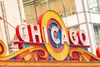 An exterior view of the Chicago Theatre featuring its illuminated Chicago marquee on a busy street in downtown Chicago.