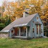 A wood cabin Vrbo with fall leaves behind in Vermont