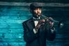 Senior African American jazz musician in vintage clothing plays trumpet.