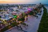 An aerial view of South Beach, Miami with the streets all lit up with colorful lights in the evening.