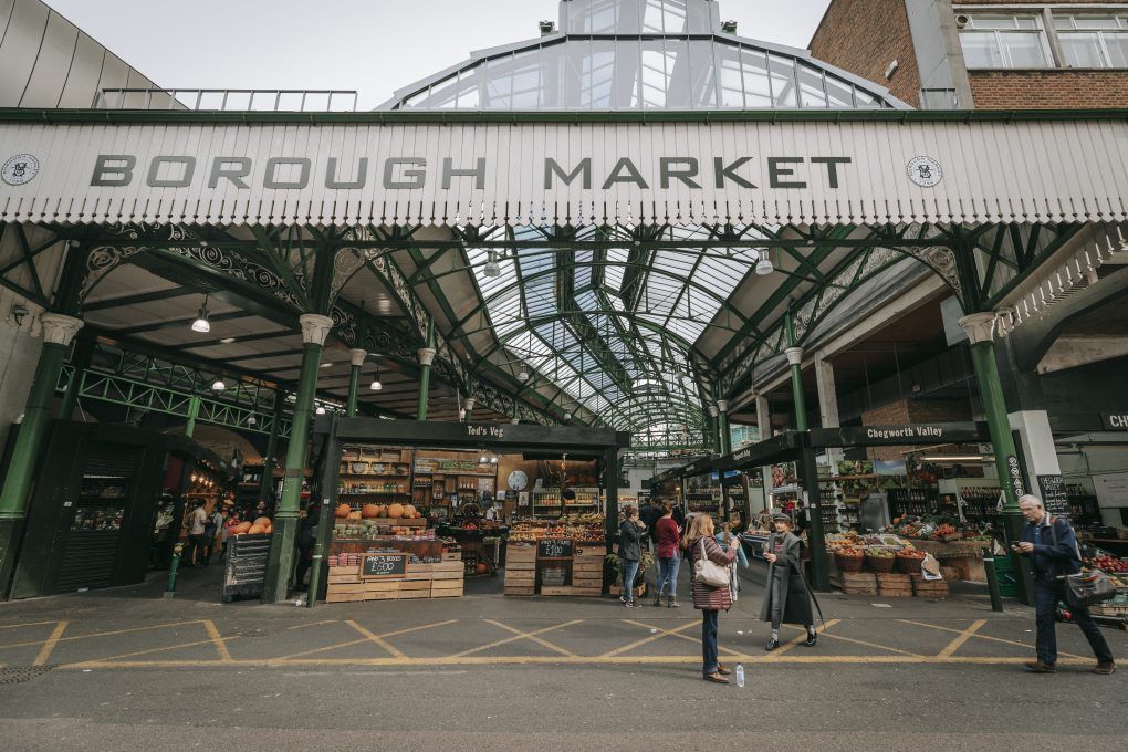 The entrance to London's Borough Market, with a vegetable stall and shoppers ready to pounce