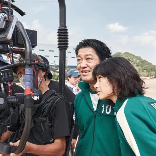Actors from Netflix's Squid Game check the camera in a behind-the-scenes shot