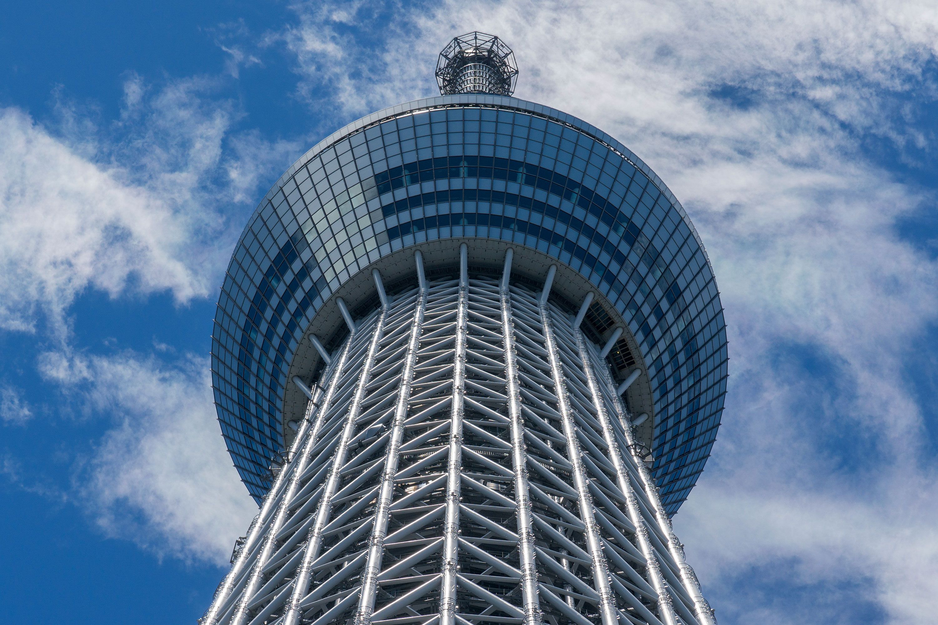 Tokyo Skytree tower in Tokyo, Japan, a tall lattice structure stretching skyward above city buildings.