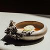 A dish is plated in a sculptural ceramic bowl at fine dining restaurant Esmé