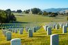 Rows of white gravestones lining a large lawn.