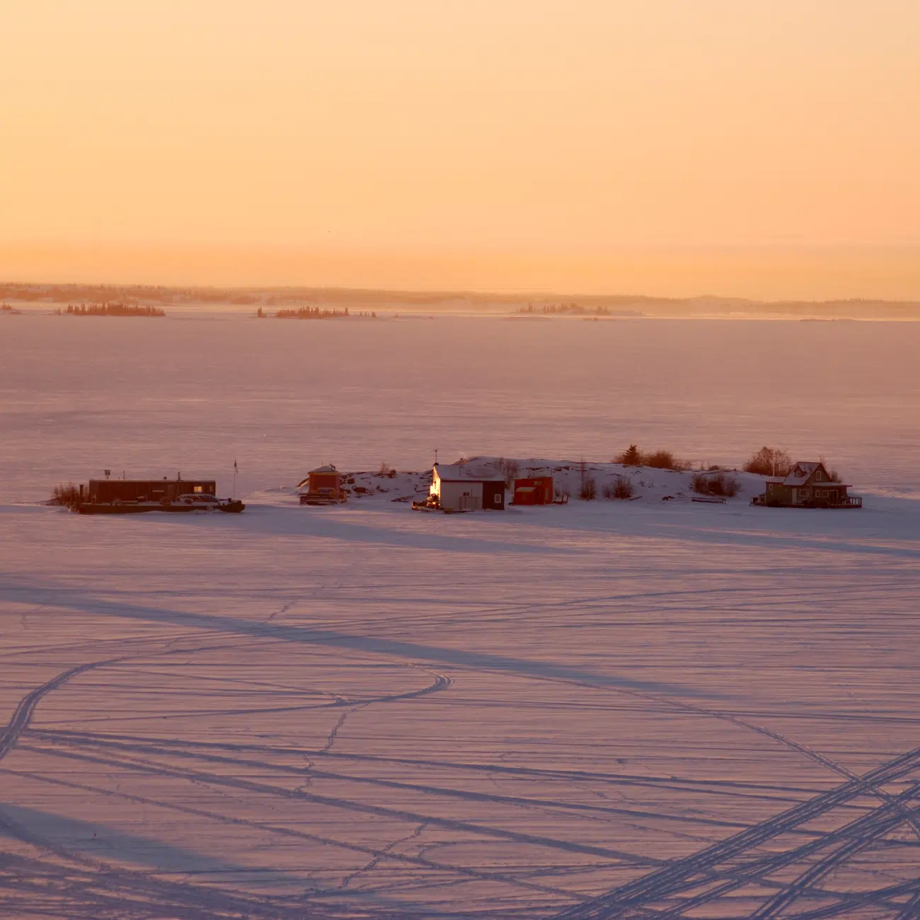Colorful houseboats frozen into Yellowknife Bay, seen at dusk