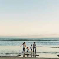 A family with two mothers and two kids paddles in the sea