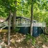 A blue and white cabin in teh woods, on the shore of Lake Lure