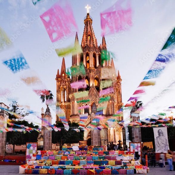 The town celebrates in style with strings of colorful perforated paper flags overhead and the cathedral in the background