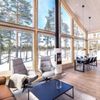 A Vrbo with vast windows looking onto a snowy forest in Finland