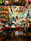 Two people look at hats inside a Panamanian market filled with trinkets