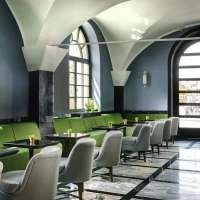 Grey and green seating in the marble-floored lobby at Hotel Balestri in Florence, Italy