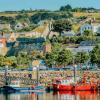 Fishing boats line the harbour with homes built up on the hillside in the picturesque village of Howth, County Dublin, Ireland