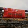 A hand-knitted patchwork sign reads Inishbofin