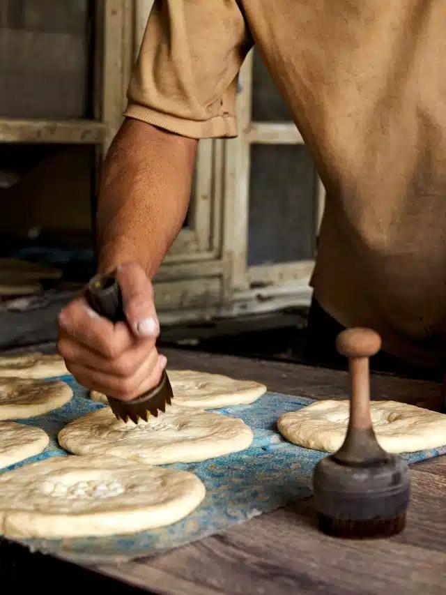 A bread maker in Dushanbe, Tajikistan, uses a hand-held stamp to put an impression of dots in the center of circles of dough