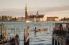 Boats and gondalas float on the water surrounding Basilica San Giorgio on a sunny day in Venice, Italy