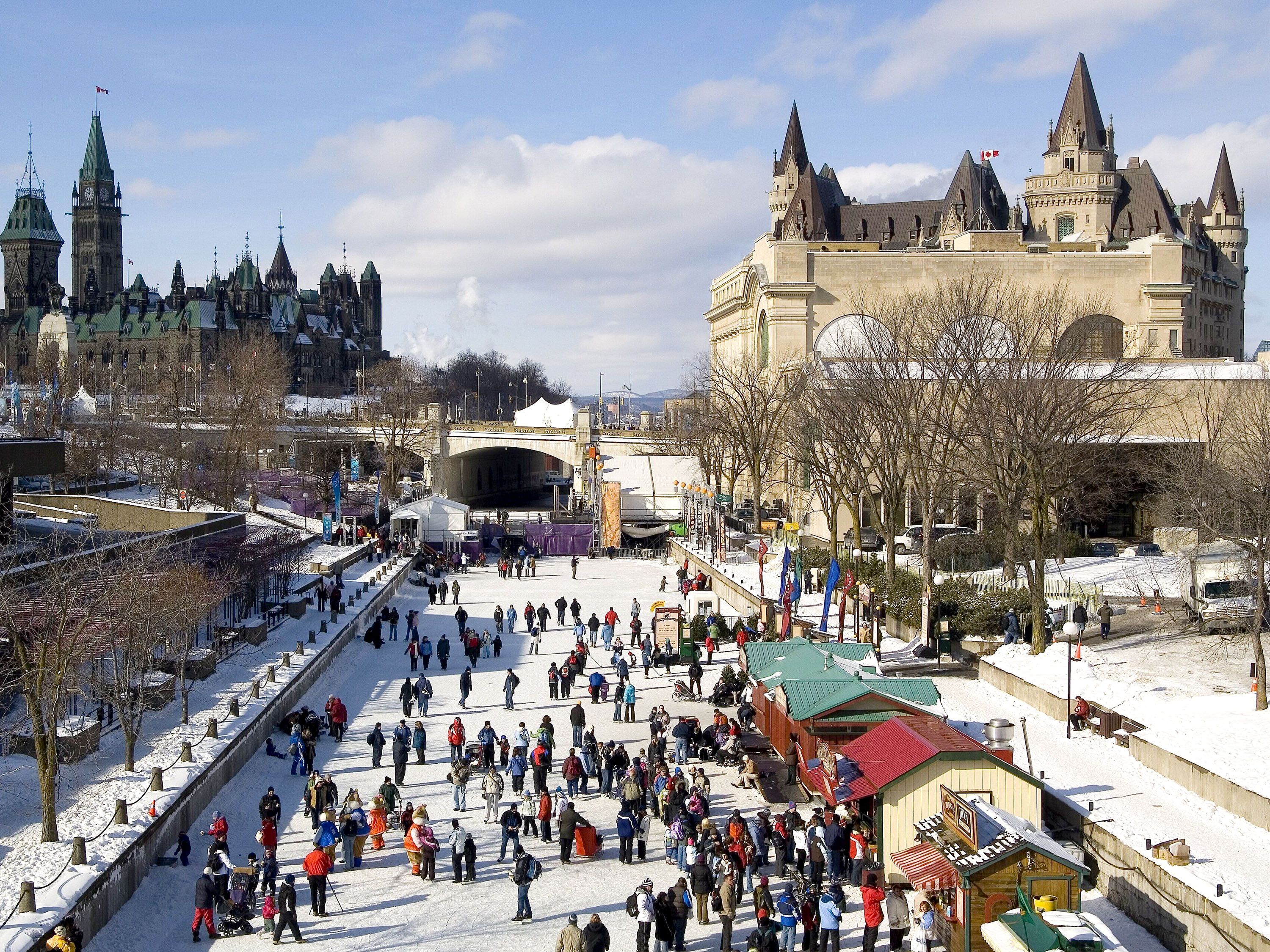Overview of a crowd of people gathered around vendors in a city center.