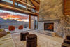 The lounge area with fireplace and chairs out on the terrace overlooking the mountains at sunset at a Vrbo rental property in Silverthorne, Colorado