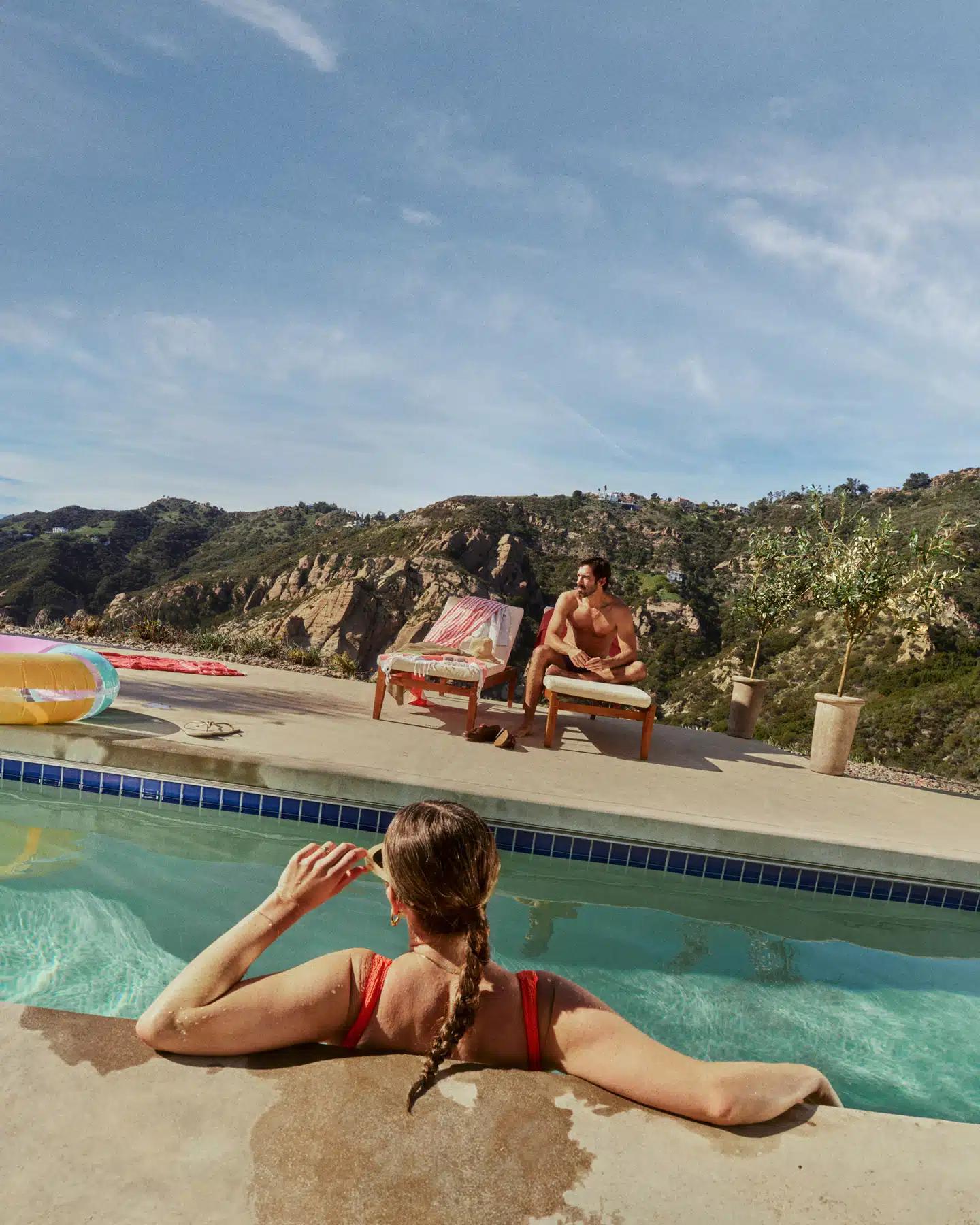 A woman in a red swimsuit and sunglasses lounges in a pool