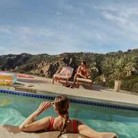A woman in a red swimsuit and sunglasses lounges in a pool
