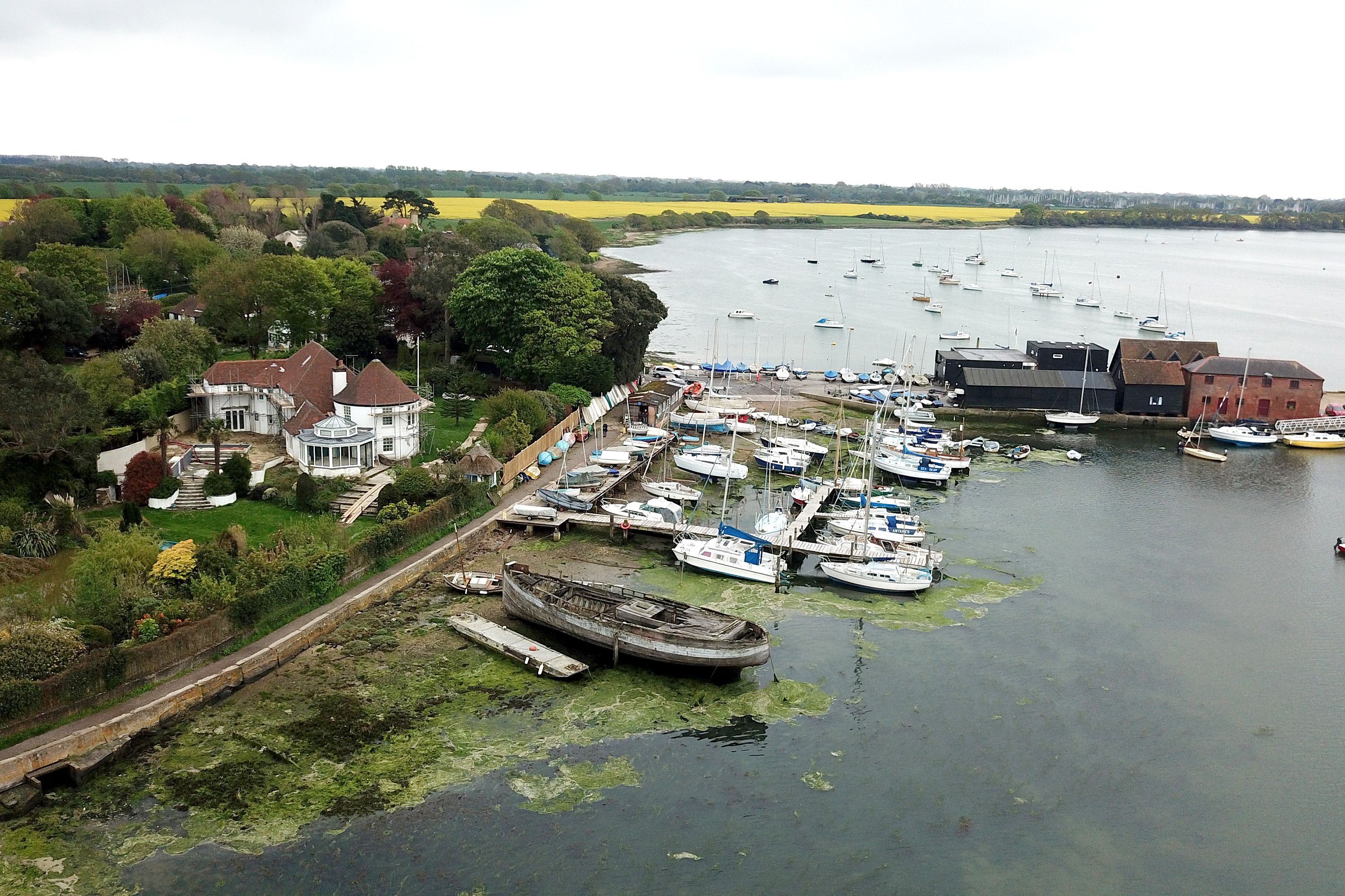 Aerial photo of boats in a harbor and a large white estate.