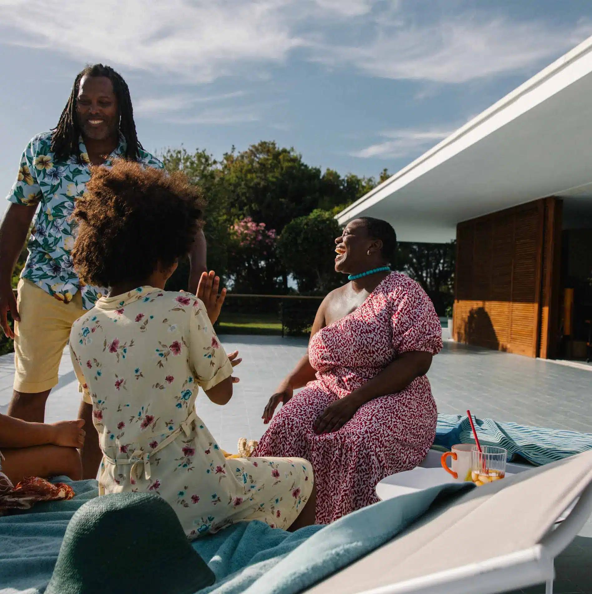 Three people laugh outside a Vrbo with a large terrace