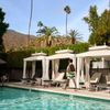 A man walks past the white cabanas that line the pool of The Colony Palms Hotel in Palm Springs, California