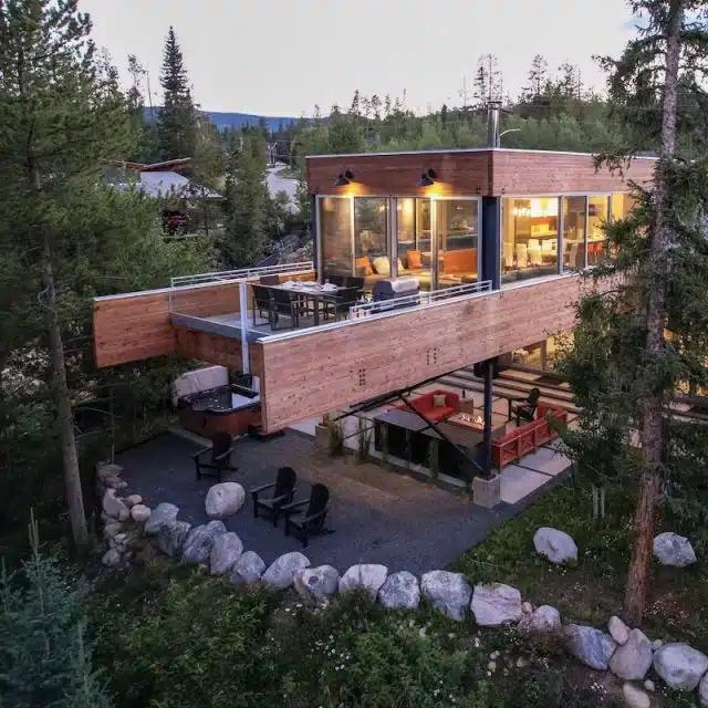 An elevated view of the upper deck and trees surrounding a mid-century Vrbo rental chalet in Winter Park, Colorado 