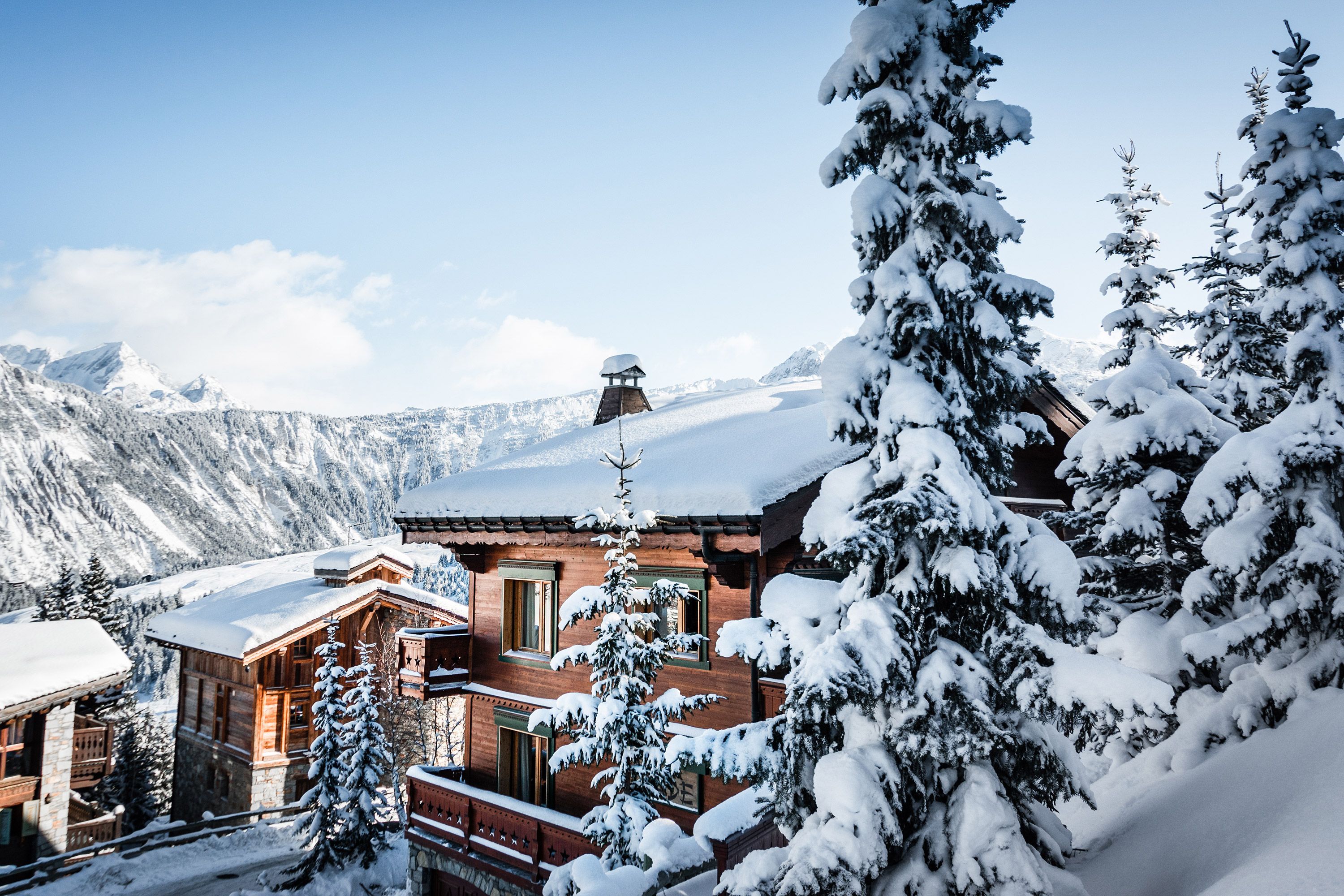 Chalets en bois dans un paysage enneigée de montagne, dans les Alpes françaises, en hiver. 
