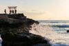 On a rocky platform by the sea, people stand at the gateway to the Shirahama Shinto shrine on Shirahama Beach in Atami, Japan