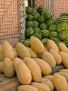 Two types of melons piled high against a doorway, Istaravshan Bazaar, Tajikistan