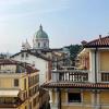 The Romanesque Duomo is seen over the top of buildings in Brescia, Italy