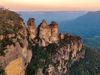 An aerial shot of the Three Sisters rock formation in the Blue Mountains National Park at sunset
