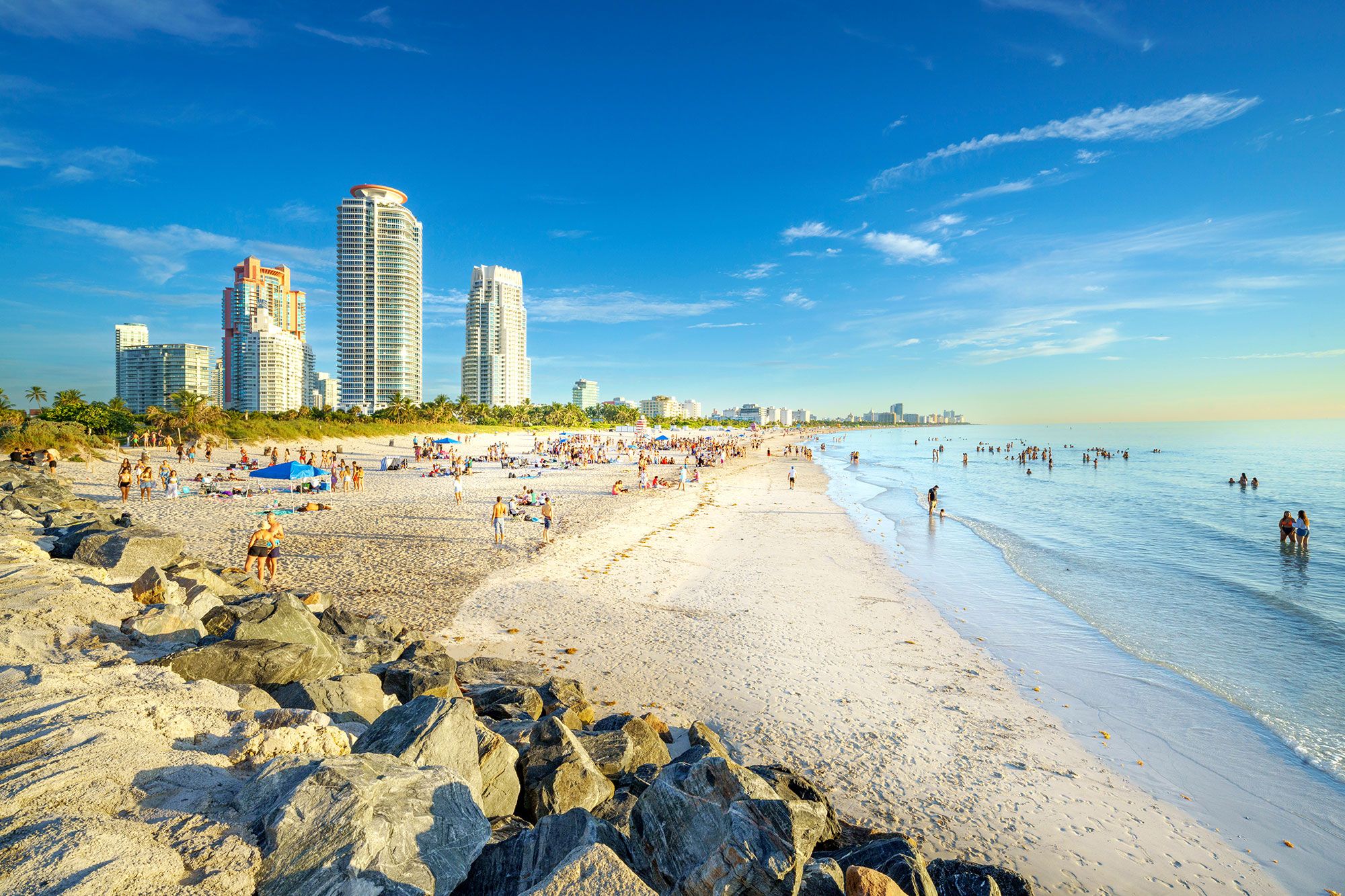 People on the beach and in the water at South Pointe Beach in Miami.
