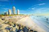 People on the beach and in the water at South Pointe Beach in Miami.