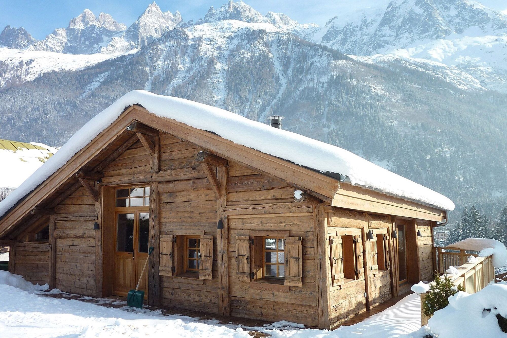 Authentique chalet en bois couvert de neige et face à la montagne, dans la vallée de Chamonix en Haute-Savoie, disponible sur Abritel