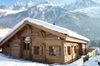 Authentique chalet en bois couvert de neige et face à la montagne, dans la vallée de Chamonix en Haute-Savoie, disponible sur Abritel