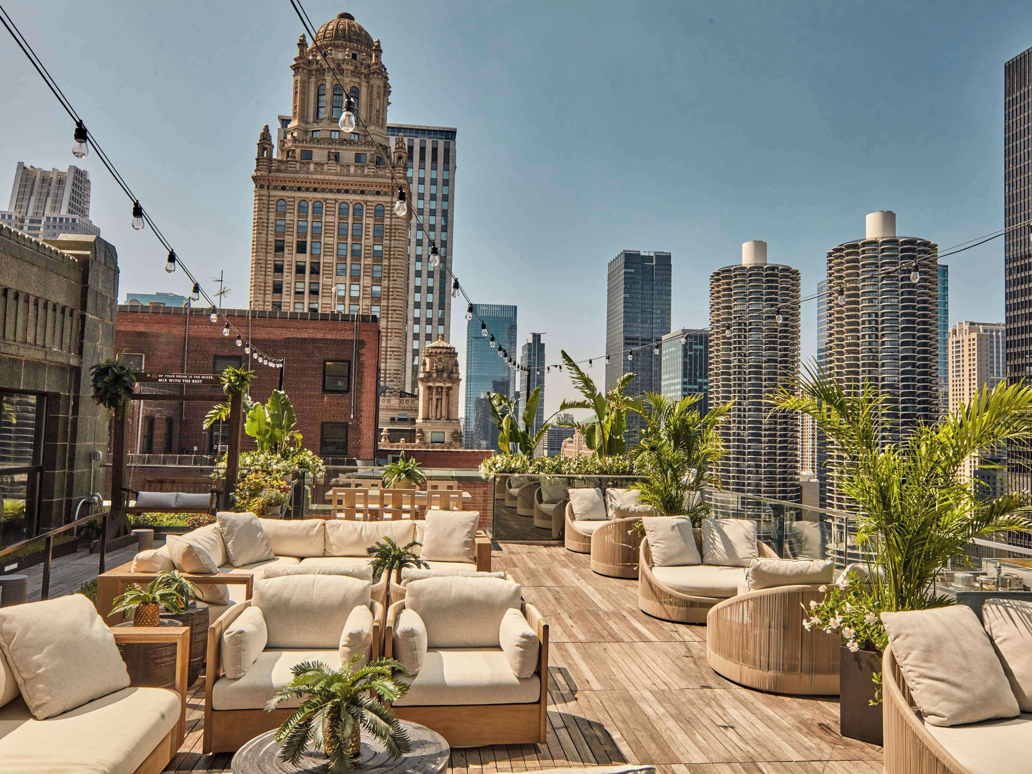 A cozy seating area on a rooftop bar overlooking the city.