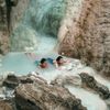 Two women bathe in the sulfur-rich waters of a natural spring in Tuscany, Italy