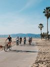 People cycle along Venice Beach bike path in Los Angeles, California