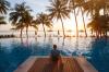 summer holiday getaway in luxury beach hotel, tourist relaxing near luxurious swimming pool at sunset, vacation on tropical island
