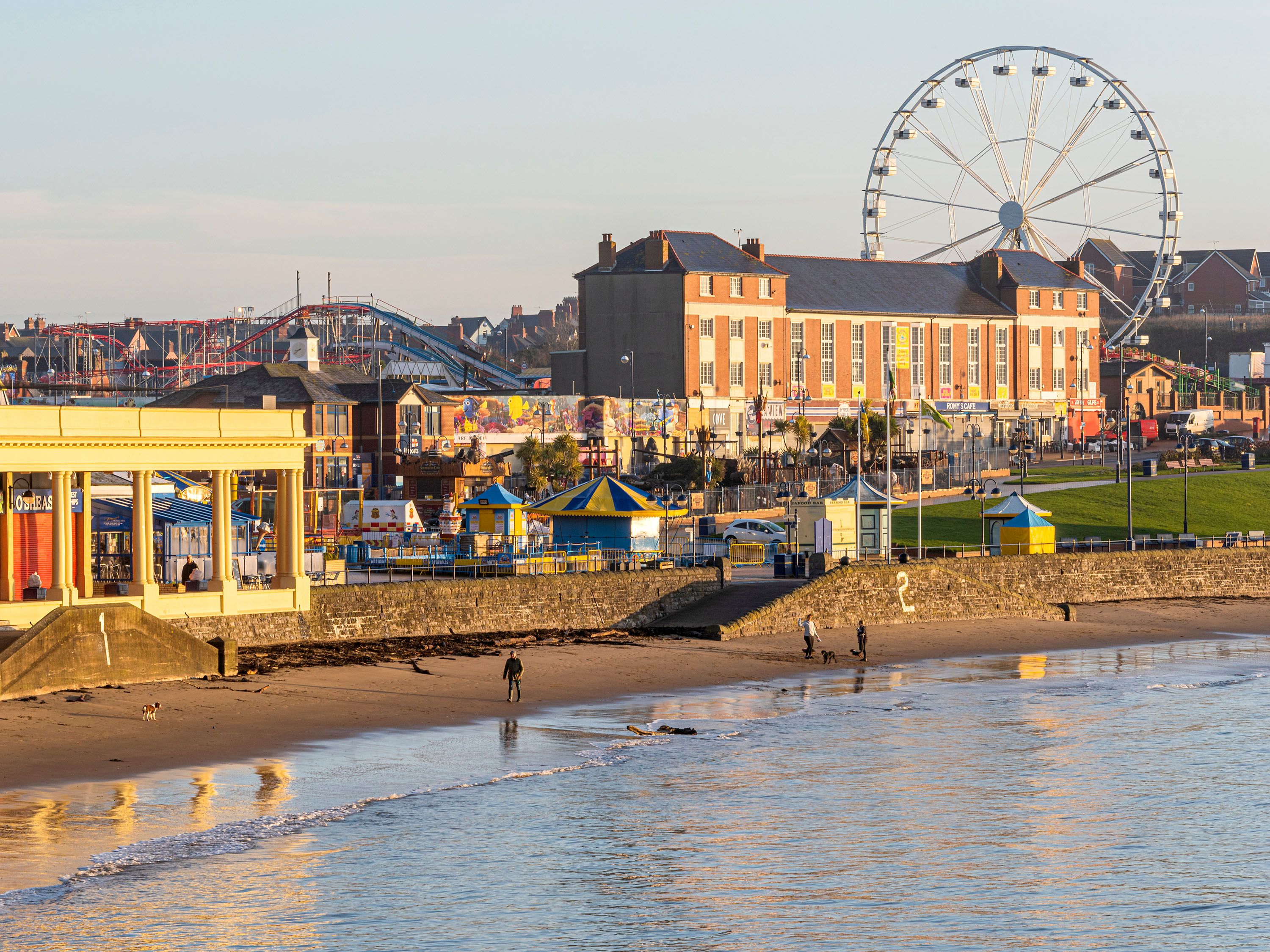 Beach with woardwalk, tents and Ferris wheel.