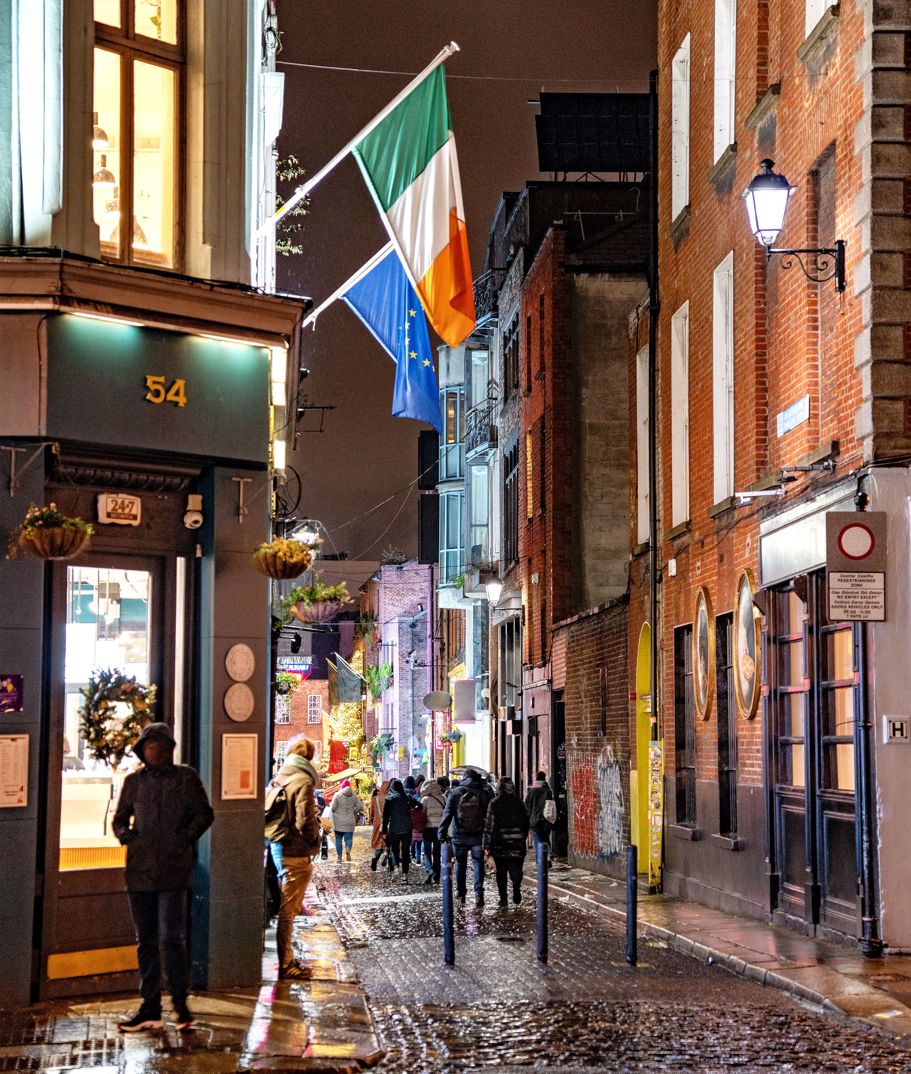 Cobblestone street and pubs with Irish flag.