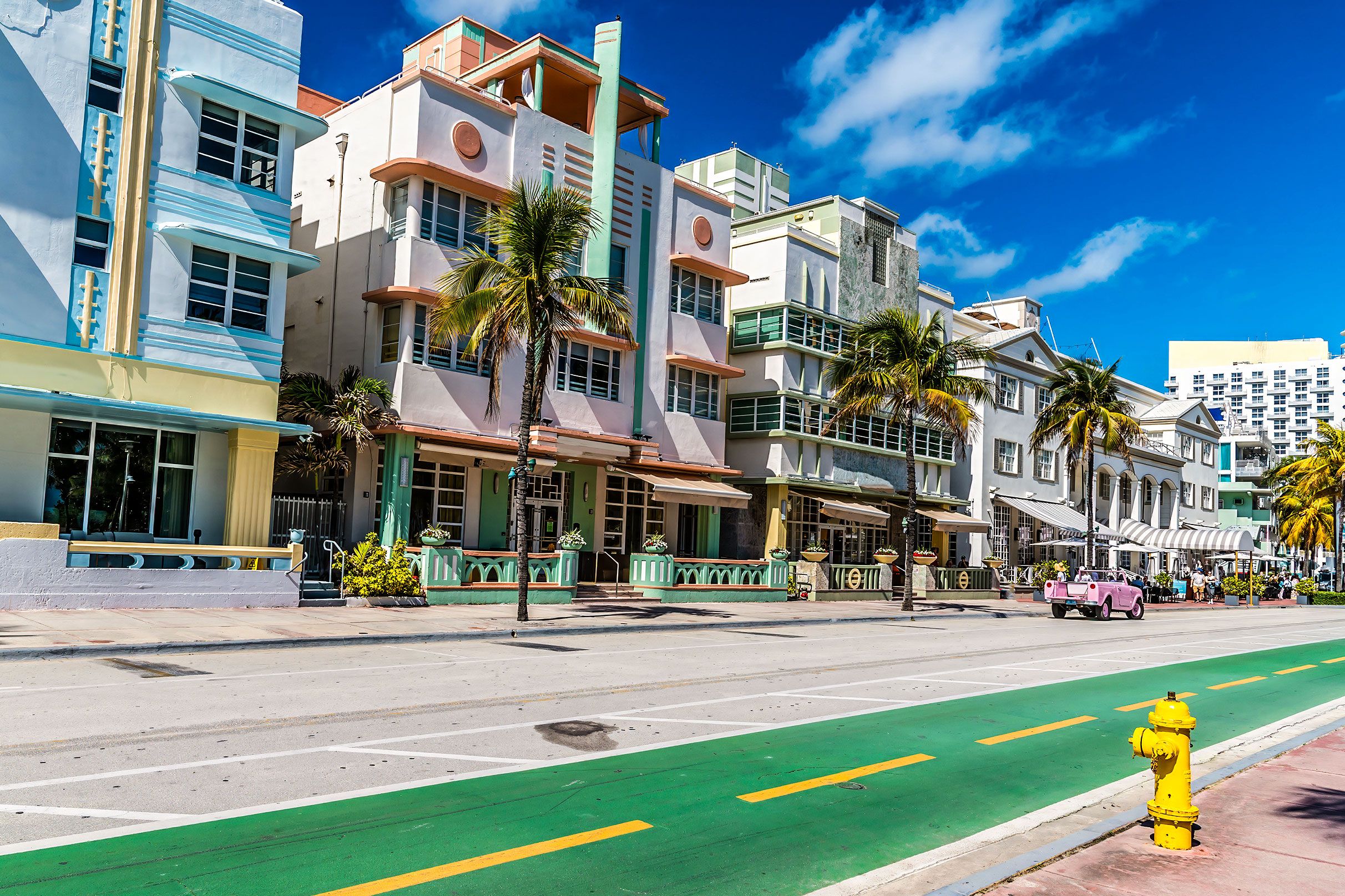 Pastel coloured art deco buildings line Ocean Drive on a bright sunny morning in South Beach.