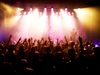 Rear view of fans with their hands up watching a rock concert.