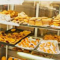 A shop window displaying Portuguese baked goods, including cookies, cakes and pasteis de nata