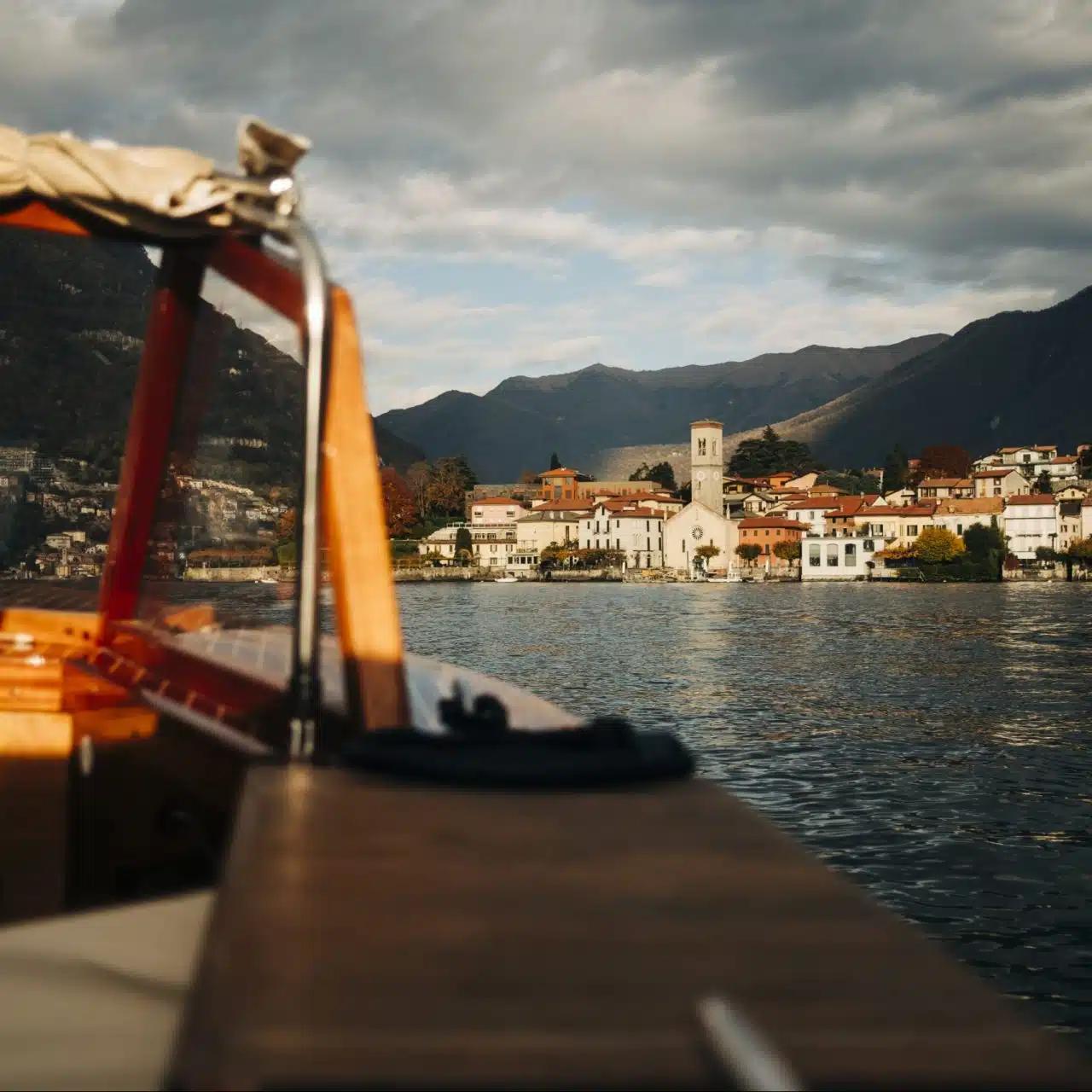 Seen from a boat, a low-lying town on the shores of Lake Como, Italy