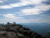 People stand at the top of a peak in the Adirondack Mountains