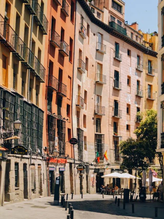 A street of colorful houses painted in orange, pink and yellow, in Madrid